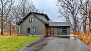 A modern two-story house with a garage, a driveway, and a lawn. - Wausau Chalet- 3BR w/ Dock & Lake w/ River Access (Wausau)