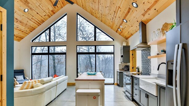 A modern kitchen with large windows, a central island, and a built-in oven. - Wausau Chalet- 3BR w/ Dock & Lake w/ River Access (Wausau)