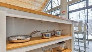 A kitchen with wooden shelves, stainless steel cookware, and a window with a view of trees. - Wausau Chalet- 3BR w/ Dock & Lake w/ River Access (Wausau)