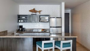 A modern kitchen with a central island, stainless steel appliances, and bar stools. - Ocean Front Penthouse in beautiful Cabo San Lucas on Medano Beach (Cabo San Lucas)