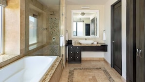 A modern bathroom with a large bathtub, a walk-in shower, and a vanity with a large mirror. - Ocean Front Penthouse in beautiful Cabo San Lucas on Medano Beach (Cabo San Lucas)