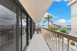 Un balcón con vistas a un puerto deportivo y palmeras.