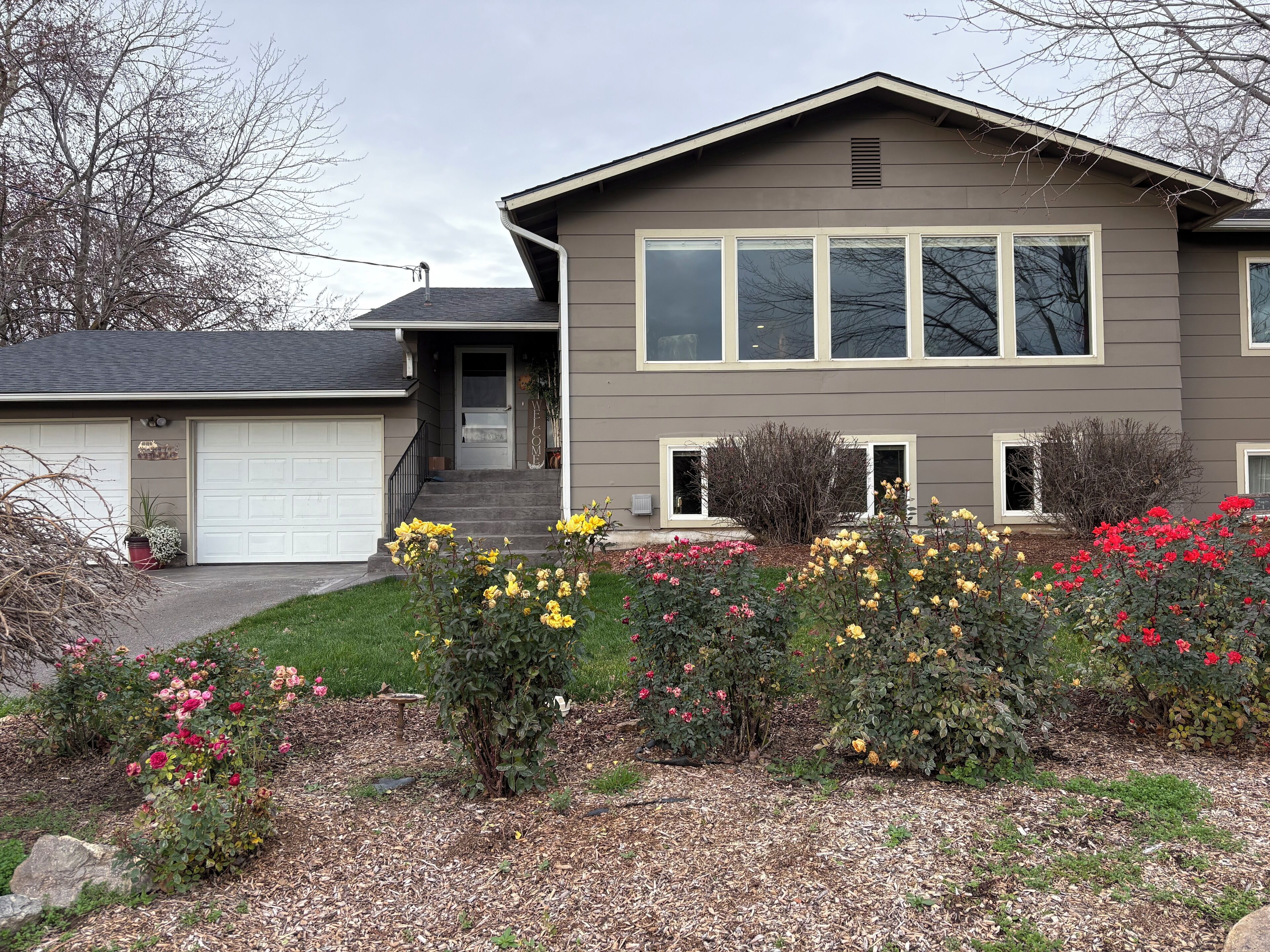 A warm welcome to our cozy, well-loved home surrounded by seasonal blooms.