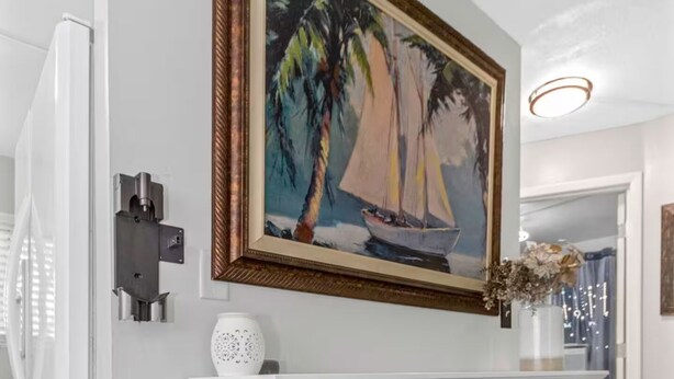 A modern living room with a white fireplace, a framed painting of a sailboat, and a decorative vase. - Family & Pet Friendly Beach Getaway (Clearwater)