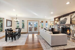 A spacious living room with a fireplace, a dining area with wooden chairs, and a large sofa. - One-of-a-Kind Mountain Home in Park City (Park City)