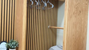A compact room with a wooden slat wall, a bed with a blue mattress, a small shelf with a plant and a sign, and a desk with a chair. - •Modern & Cozy apartment near top attractions•
Stadium,beaches ,downtown & more! (Jacksonville)