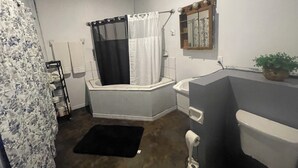 Un baño con ducha, inodoro y lavabo.