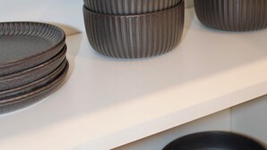 A set of stacked, ribbed bowls on a white shelf. - Studio - Cozy Downtown Hideaway (Greater Sudbury)