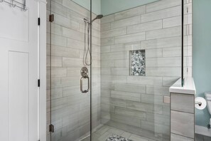 A modern bathroom with a glass-enclosed shower, light-colored tiles, and a small decorative window. - Close to Clemson with a beautiful view of Keowee! (Seneca)