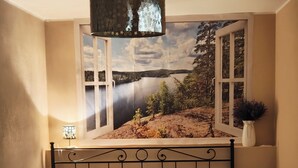 A bedroom with a bed, a window with a scenic view, a hanging lamp, and a small table with a bottle. - Romantic house. Veranda with panoramic view. Garden. Barbecue. Parking space (Colonno)