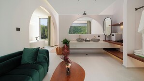 A modern living room with a green sofa, a wooden coffee table, and a vase with flowers. There is a large window with a view of greenery outside. - Bright Moon Valley Smart Hotel (Anqing)