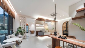 A modern interior with a dining area, kitchen, and seating space. - Bright Moon Valley Smart Hotel (Anqing)