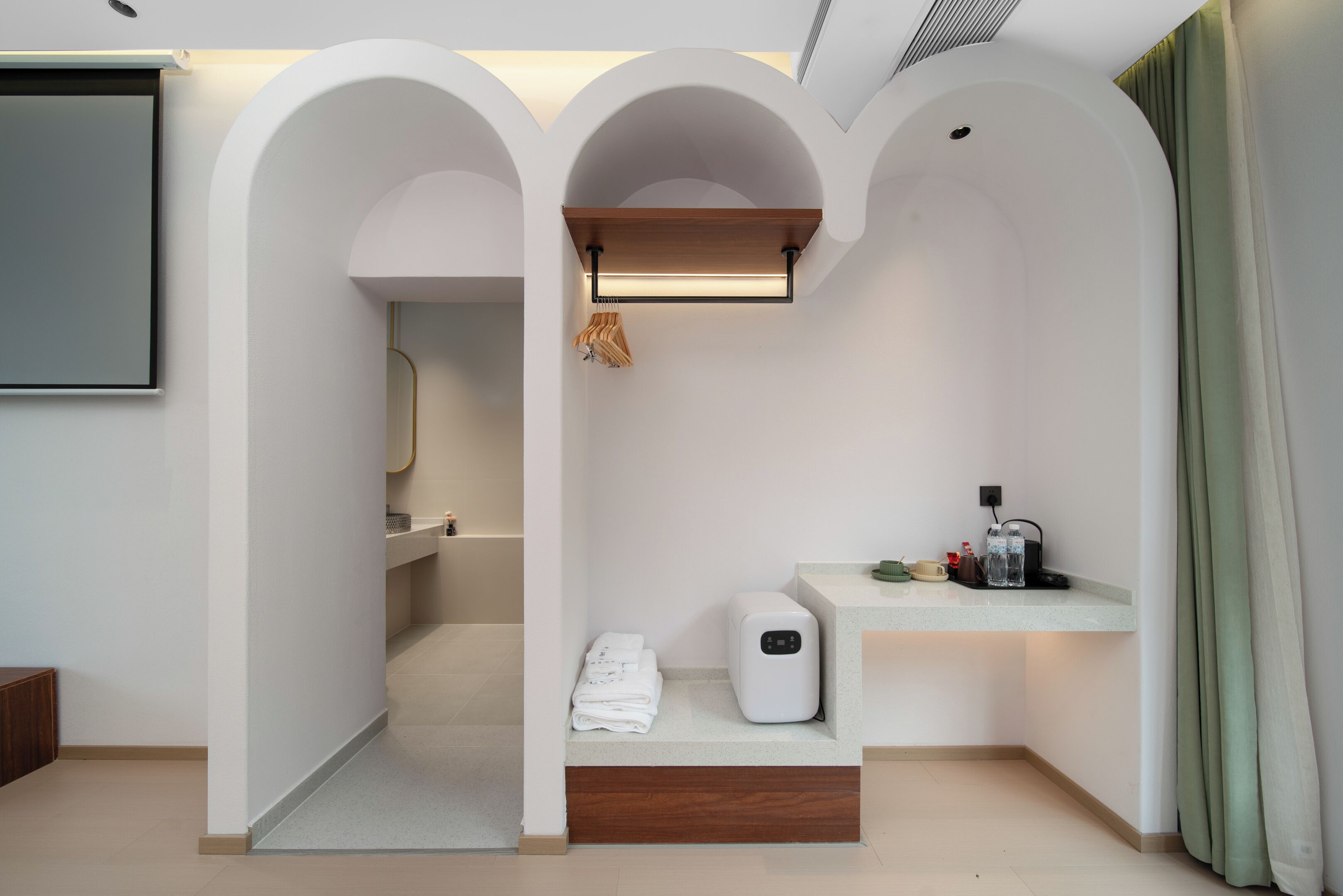 Ein modernes Badezimmer mit Dusche, Handtuchhalter, Seifenspender und Ablage für Toilettenartikel.