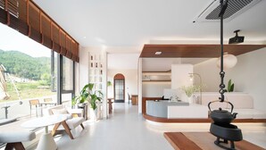 A modern interior with a kitchen area, dining space, and a view of the outdoors. - Bright Moon Valley Smart Hotel (Anqing)