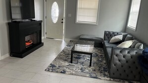 A living room with a fireplace, a sofa, a coffee table, and a television. - Cozy and comfortable accommodation for six guests. (Dalton)