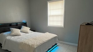 A bedroom with a bed, pillows, a headboard, a window, and a bedside table. - Cozy and comfortable accommodation for six guests. (Dalton)