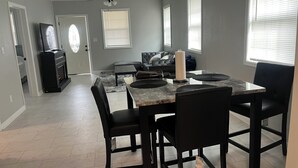 A modern kitchen with a marble countertop, black chairs, and a ceiling fan. - Cozy and comfortable accommodation for six guests. (Dalton)