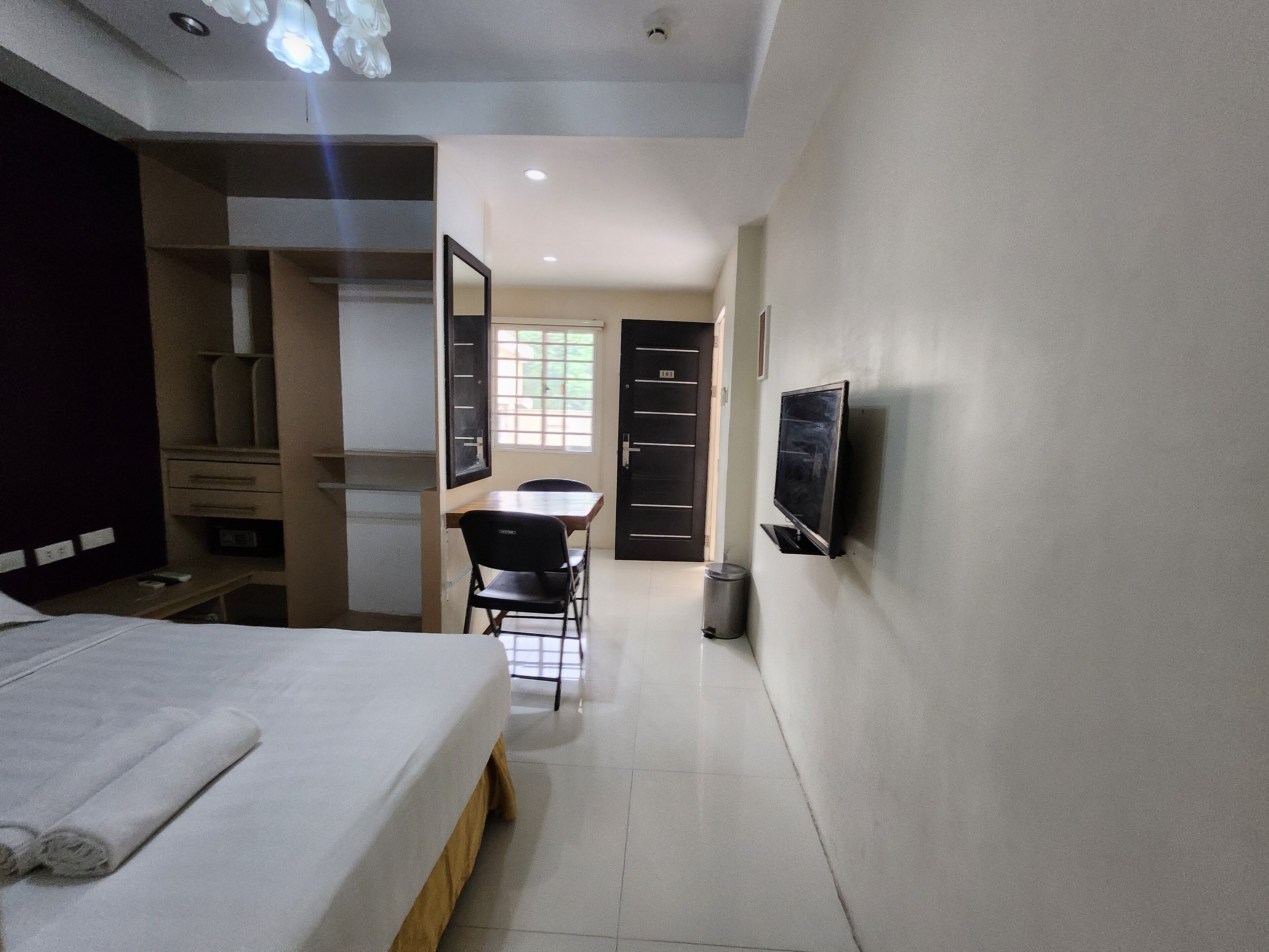 Une chambre d’hôtel équipée d’un lit, d’un bureau, d’une chaise, d’une télévision et d’une armoire.