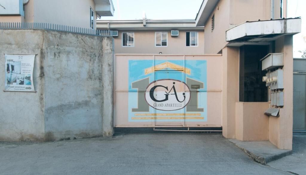 A building entrance with a large sign reading "GRAND APARTELLE" and a logo.
