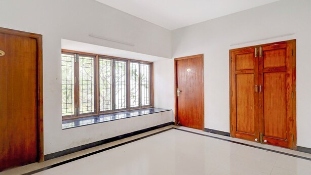 A room with a large window, two wooden doors, and a tiled floor. - Fabhotel Ravana Kottai (Chennai)