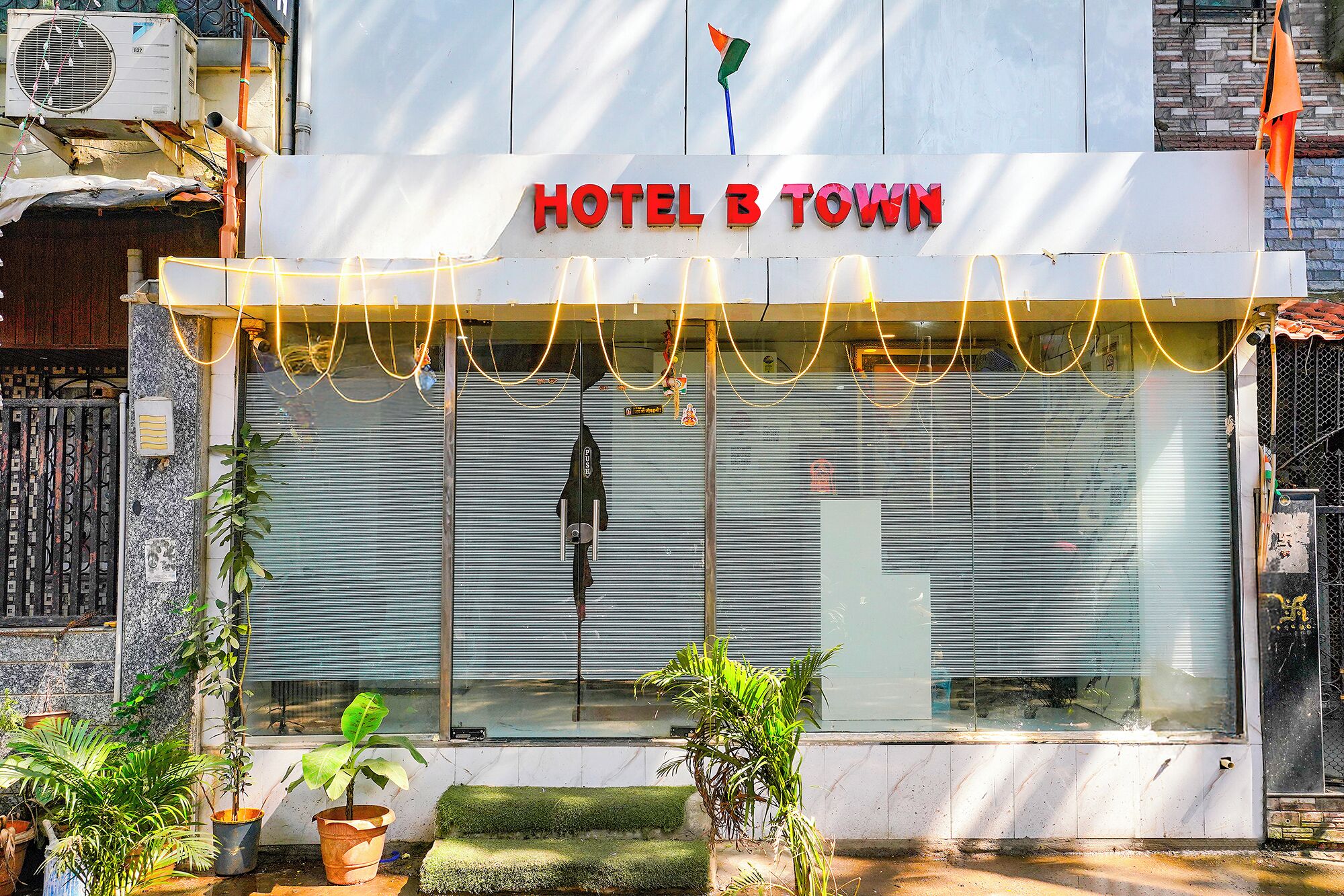 Ein Hotel Eingang mit einem Schild, auf dem 'HOTEL B TOWN' steht.