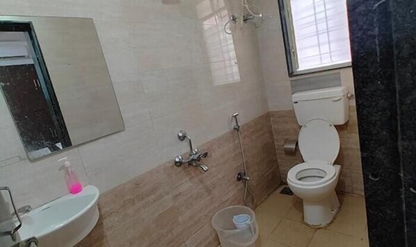 A bathroom with a sink, mirror, shower, and toilet. - Fabhotel Pristine (Pune)