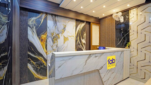 A hotel reception desk with a marble top and a logo. - Fabhotel Shri Vishwanath (Varanasi)
