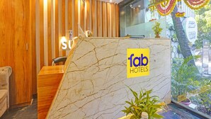 Ein Empfangsbereich mit Marmorplatte, Holzvertäfelung an den Wänden und einem Schild für 'fab hotels'.