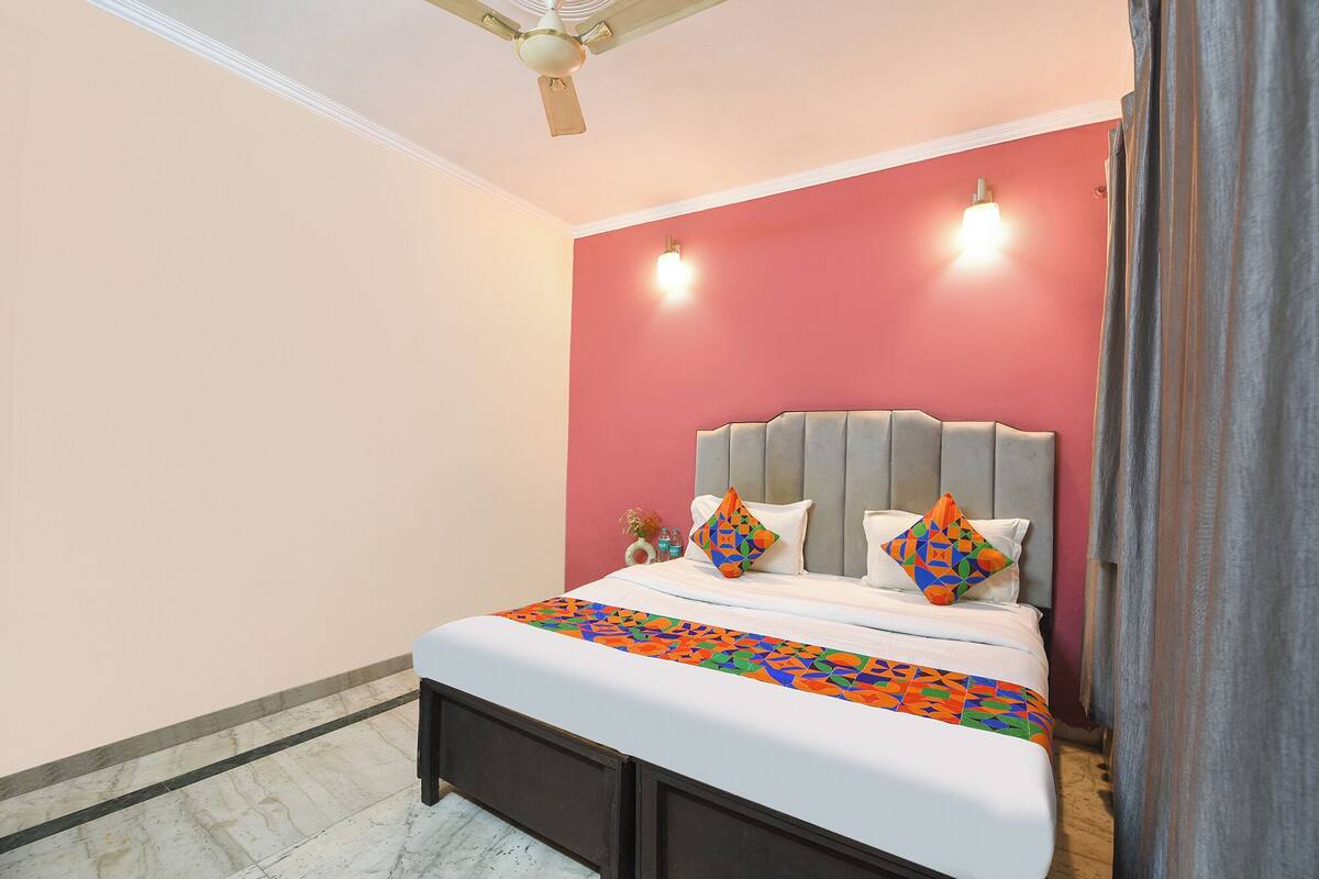Un dormitorio con una cama, cabecera y ventilador de techo.