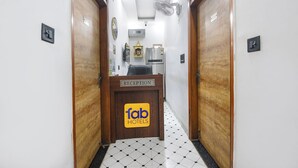 A hotel reception area with a reception desk labeled 'fab hotels'. - Fabhotel The Dream Inn (Faridabad)