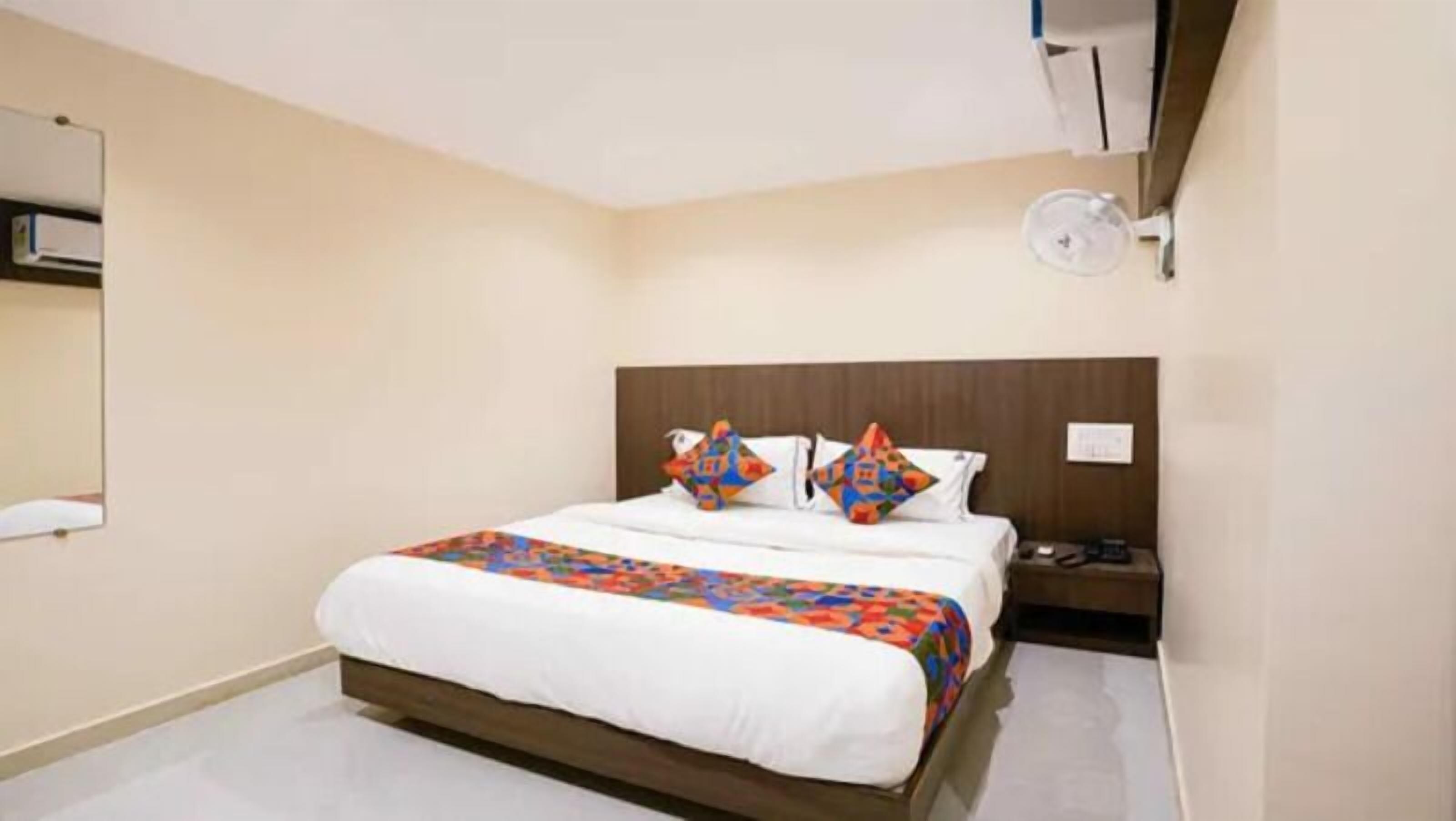 Een hotelkamer met een bed, een nachtkastje en een bijzettafeltje.
