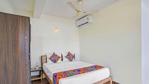 A bedroom with a bed, a wooden wardrobe, a nightstand, a ceiling fan, and an air conditioning unit. - Via Simba resort - 200m From Arambol Beach (Arambol)
