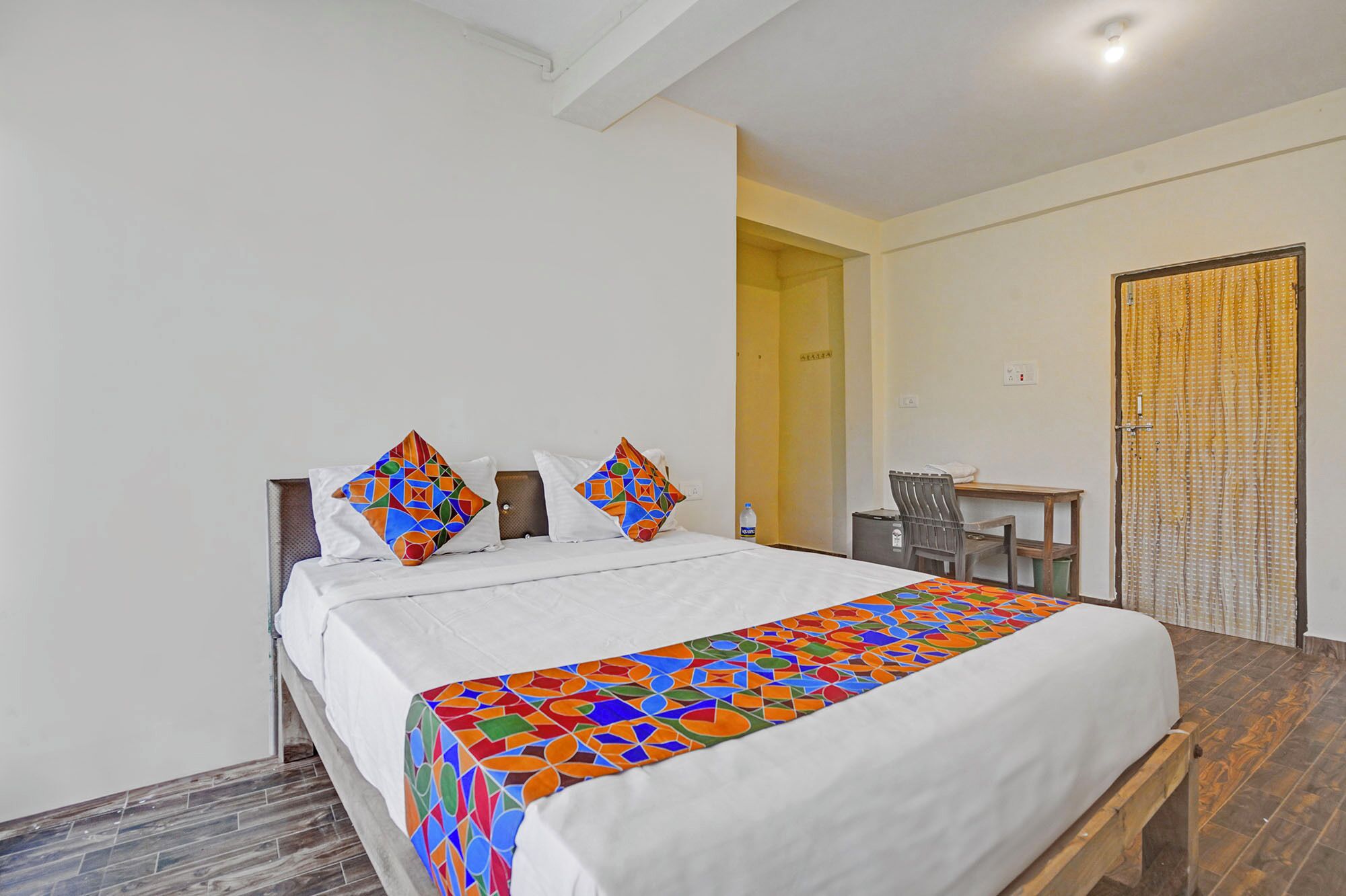 Een hotelkamer met een groot bed, een bureau en een stoel.