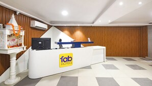 A hotel reception desk with a 'Tab Hotels' sign, a computer, and a small shrine with marigold flowers. - FabHotel Prime Elvilla I-@ Rajouri Garden, Delhi (New Delhi)