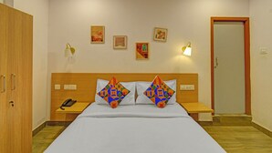 A hotel room with a bed, two nightstands, a phone, and a door. - Fabhotel Casa Grand Himayathnagar (Hyderabad)