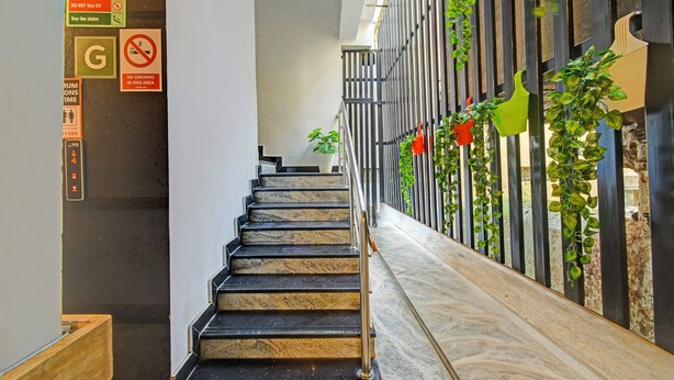 A staircase with a metal railing, a fire safety sign, and a no smoking sign. - Fabhotel Casa Grand Himayathnagar (Hyderabad)