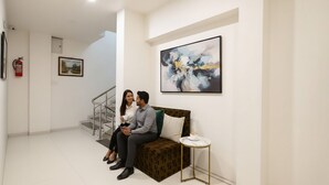 A modern interior with a sofa, a small table, and abstract art on the wall. - FabHotel Apple - Nr. by ITI (Indore)