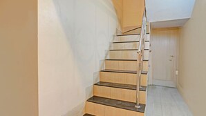 A staircase with metal railings and wooden steps leading to a door at the top. - Fabhotel Stay Land Plus (Mumbai)