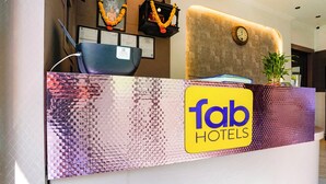 A reception desk with a 'fab hotels' sign, framed certificates, and a clock on the wall. - Fabhotel Gavalidev (Navi Mumbai)