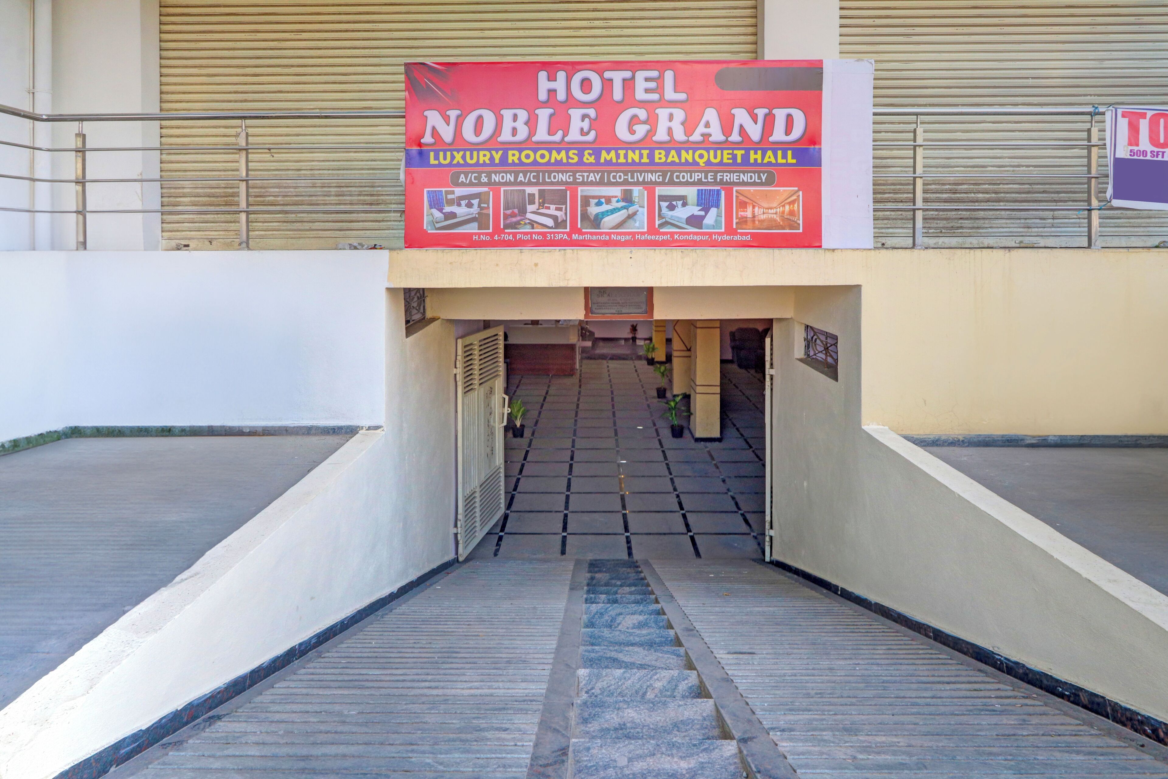 A hotel entrance with a signboard advertising luxury rooms and a mini banquet hall.
