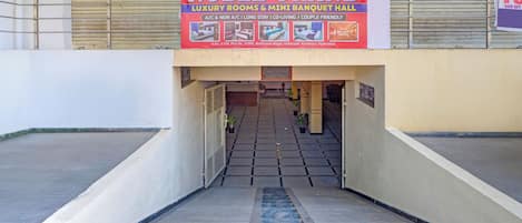 A hotel entrance with a signboard advertising luxury rooms and a mini banquet hall.