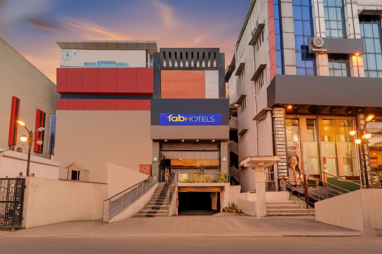 Una entrada de hotel moderna con un llamativo letrero de 'fabHOTELS', una escalera que conduce al vestíbulo y un frente de vidrio a la derecha.