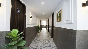 Corredor com placa indicando o quarto 304, um vaso de planta e uma moldura na parede.