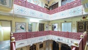 A multi-level atrium with ornate railings and traditional artwork. - Fabhotel Khandaka Mahal (Jaipur)