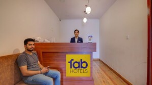 A hotel reception area with a wooden reception desk labeled 'fab hotels'. - Fabhotel Sri Udupi Park (Bengaluru)