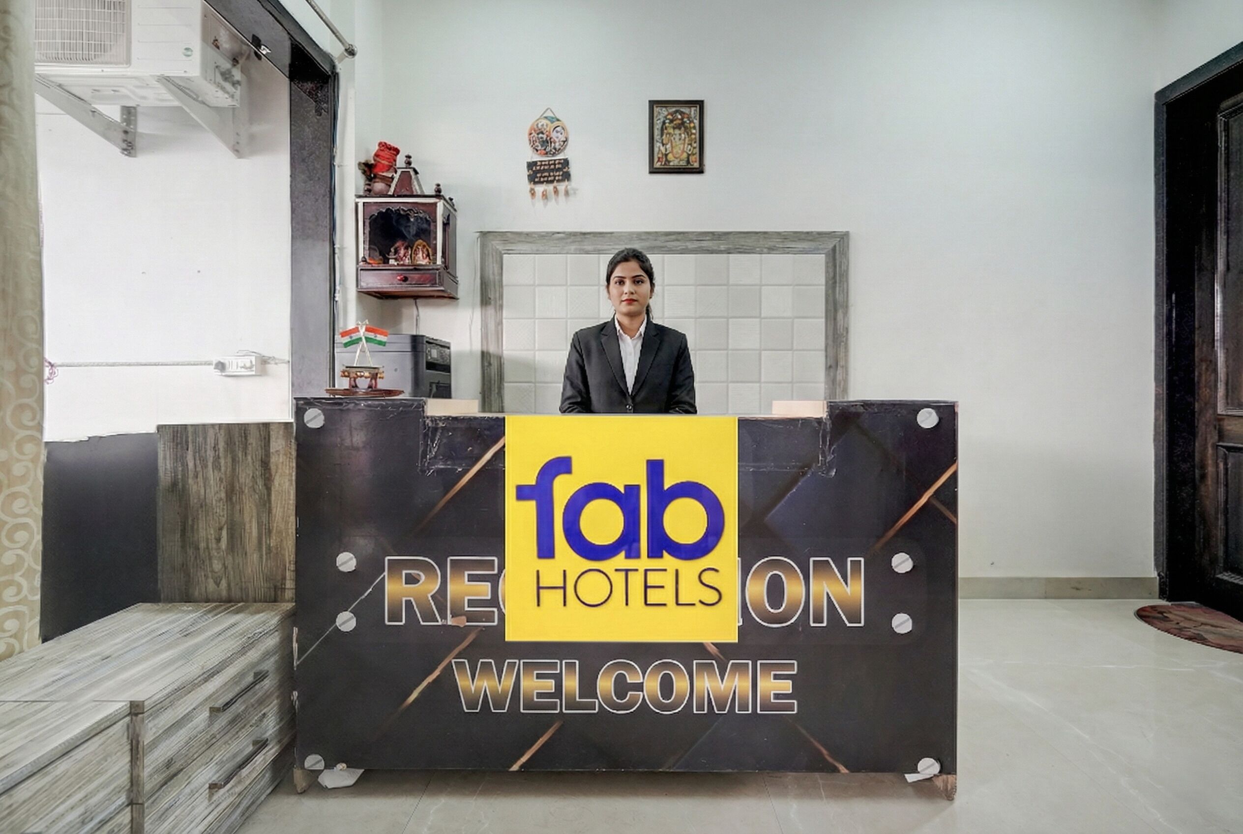 A reception desk with a sign reading "fab hotels welcome".