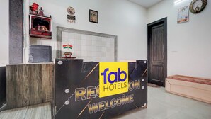 Una recepción con un cartel que dice 'fab hotels on welcome', un reloj y un calendario en la pared.