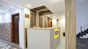 A hotel reception area with a marble counter, a check-in desk, and a staircase. - Fabhotel Vrrinda Residency (Varanasi)