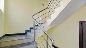 Un escalier avec des rampes en métal et des marches en marbre menant à un palier.