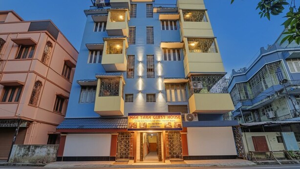 Un edificio de varios pisos con un letrero que dice 'MAA TARA GUEST HOUSE'.